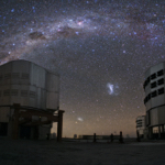 Two large telescope buildings with a sky full of stars.