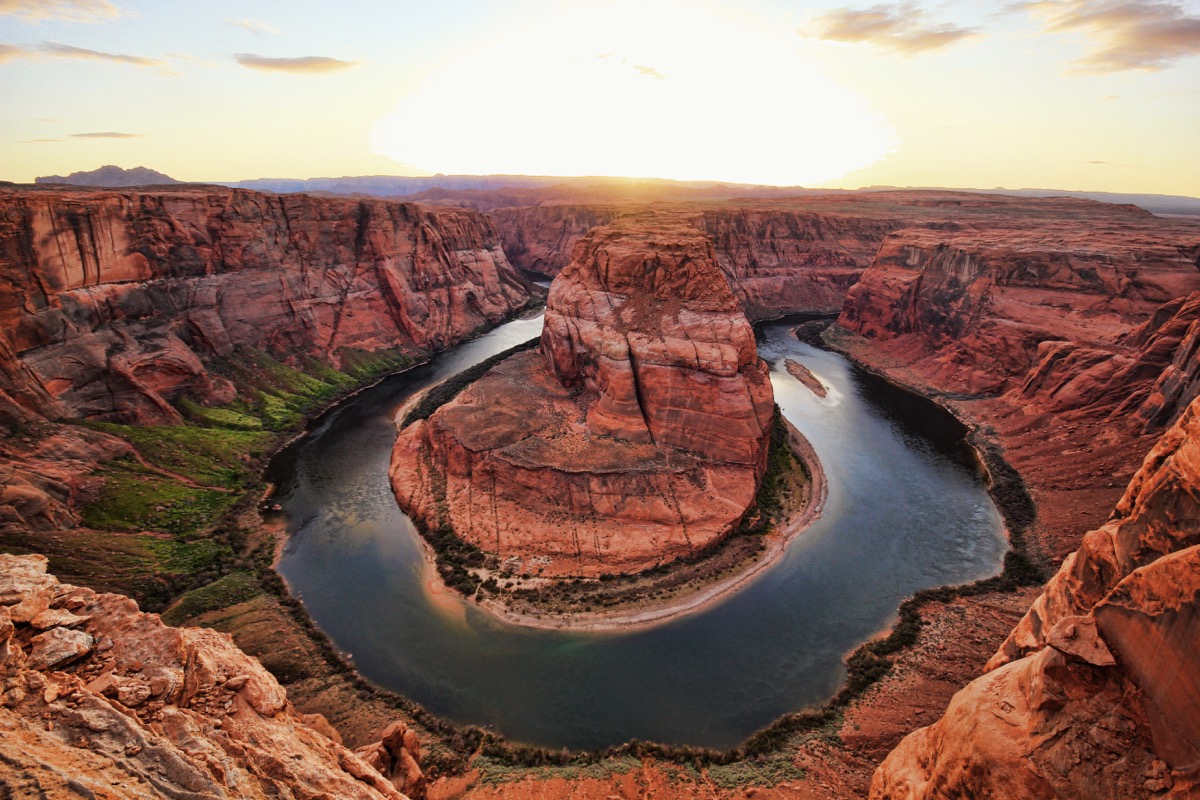 A horseshoe shaped river curving around a red rock canyon