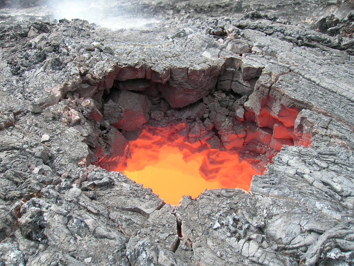 A hole in rocky earth showing glowing lava