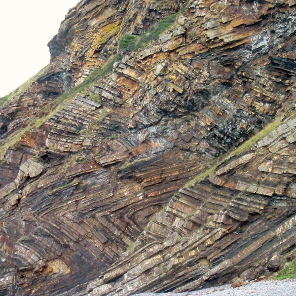 A rock formation with folds that zig zag in chevron shapes