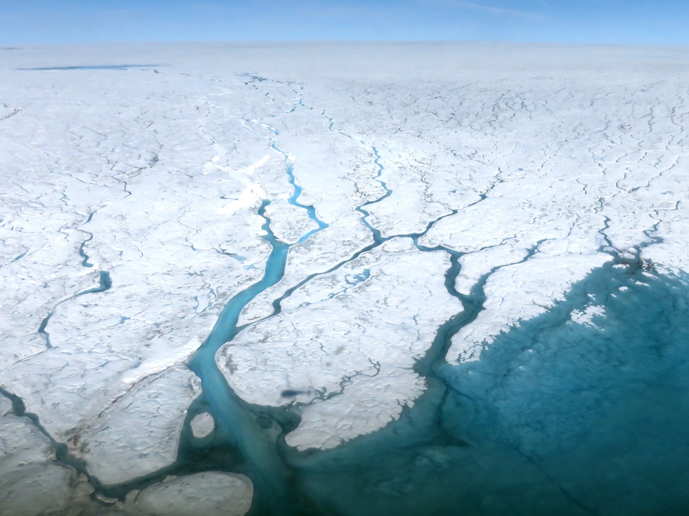 streams of ice melt running through ice sheets