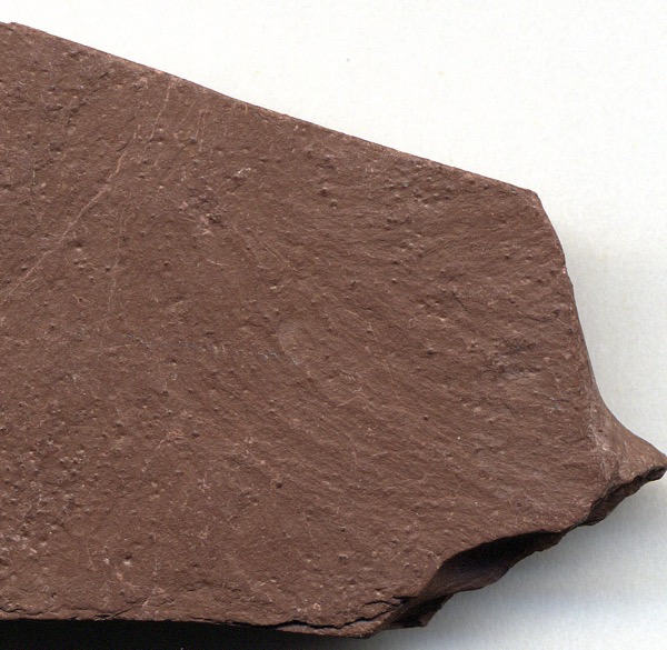 A flat reddish-brown rock sample.