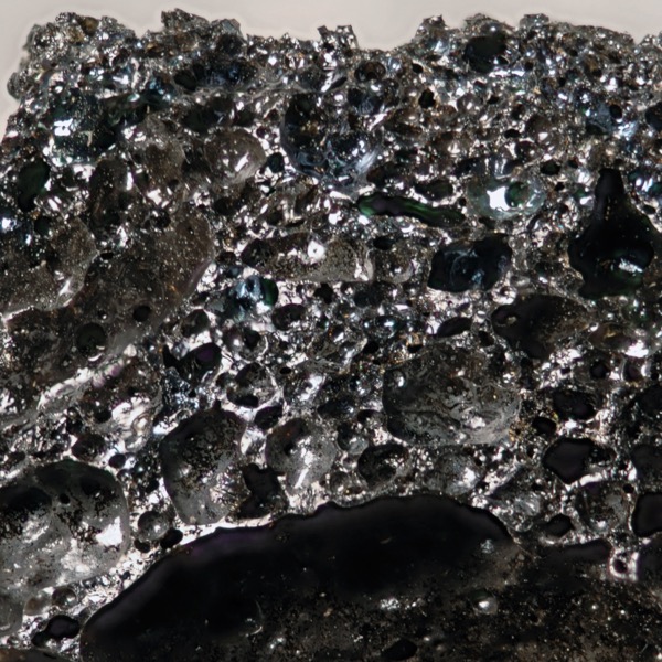 A black shiny porous rock