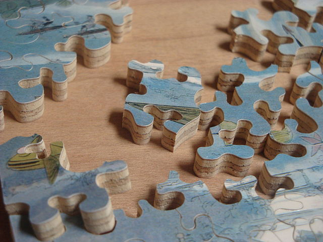 Photograph of a partially completed wooden jigsaw puzzle.