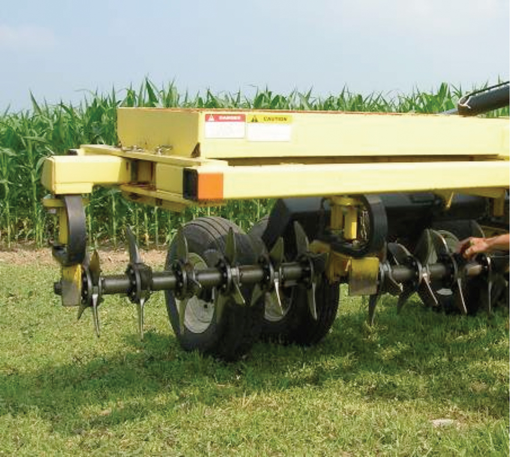aerator compactor in a green field next to tall crops