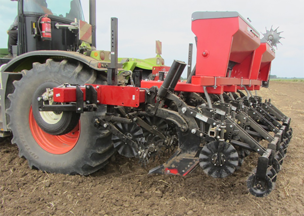 strip tiller attached to a red tractor