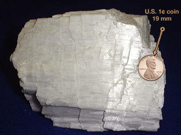 Image of wollastonite, a crystal showing step-like cleavage on one side. All steps are along the same direction of cleavage.