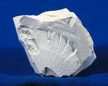 Specimen of kaolin, a white clay mineral, with a chalky appearance.
