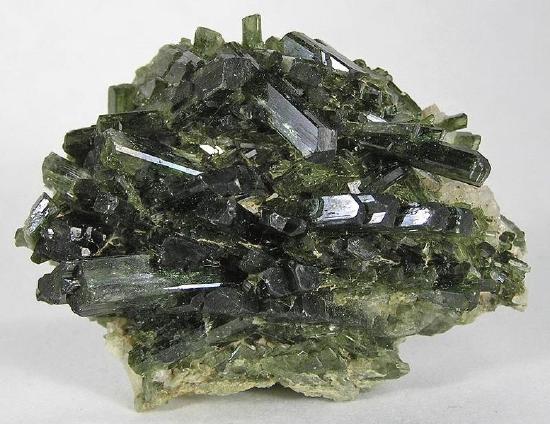 Dark green prismatic crystals piled in all directions
