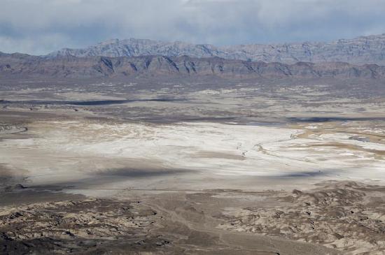 Satellite image of desert dry lake or playa surrounded by mountains.