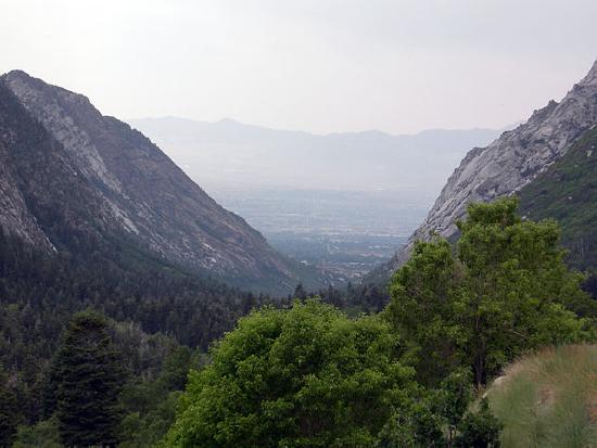 A valley with a U shape that shows steep cliffs on the sides and a wide-flat bottom