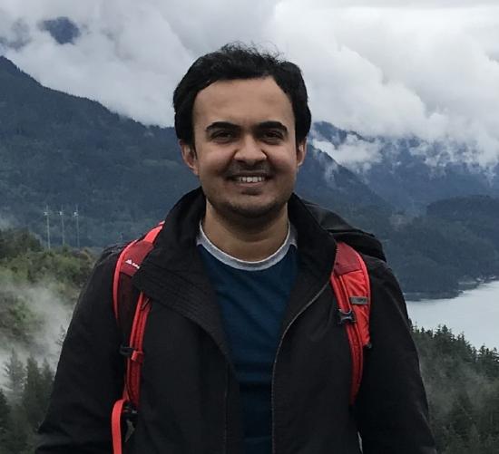 Neel backpacking in the clouds, smiling