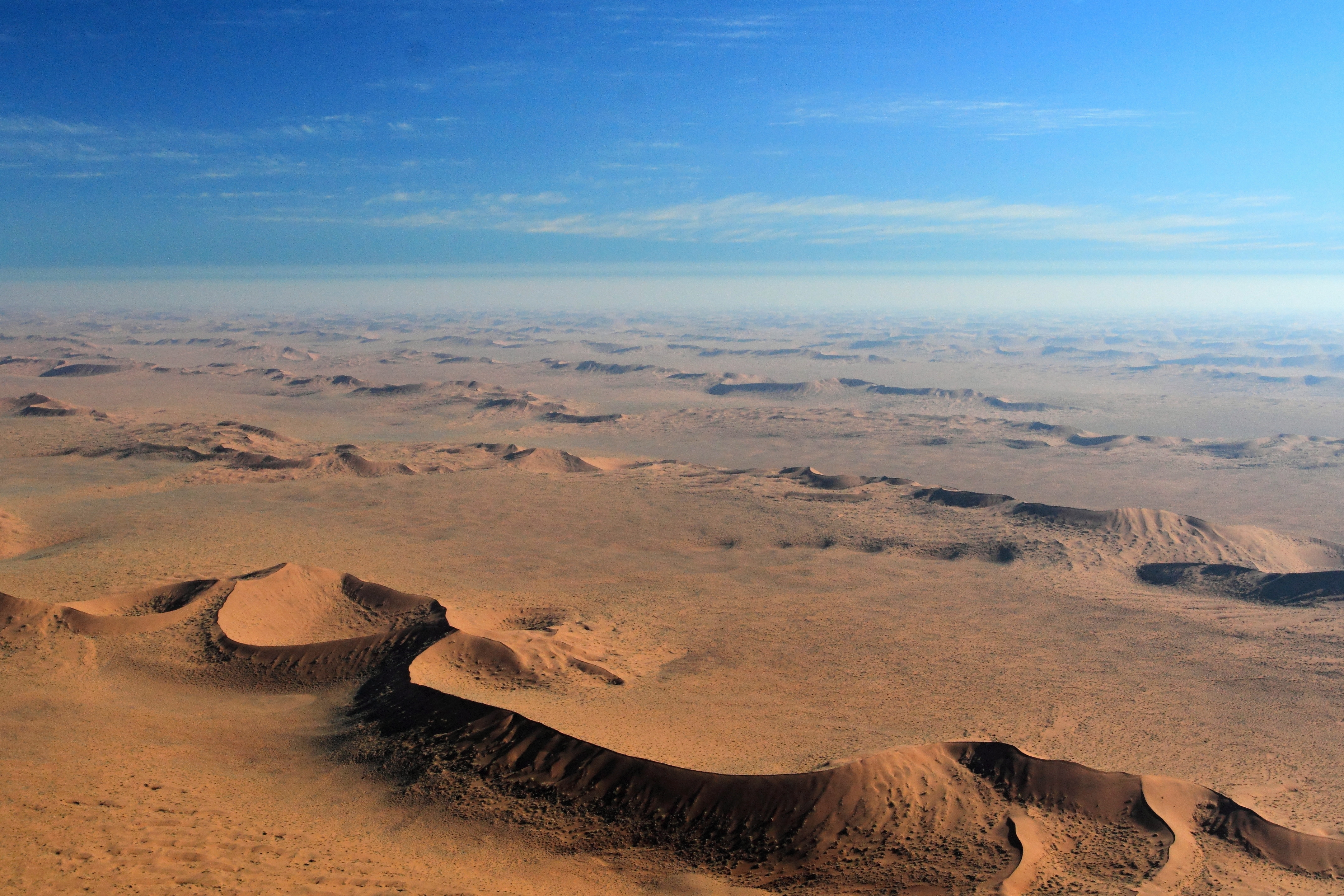 An arid desert landscape with blue skies in the background.
