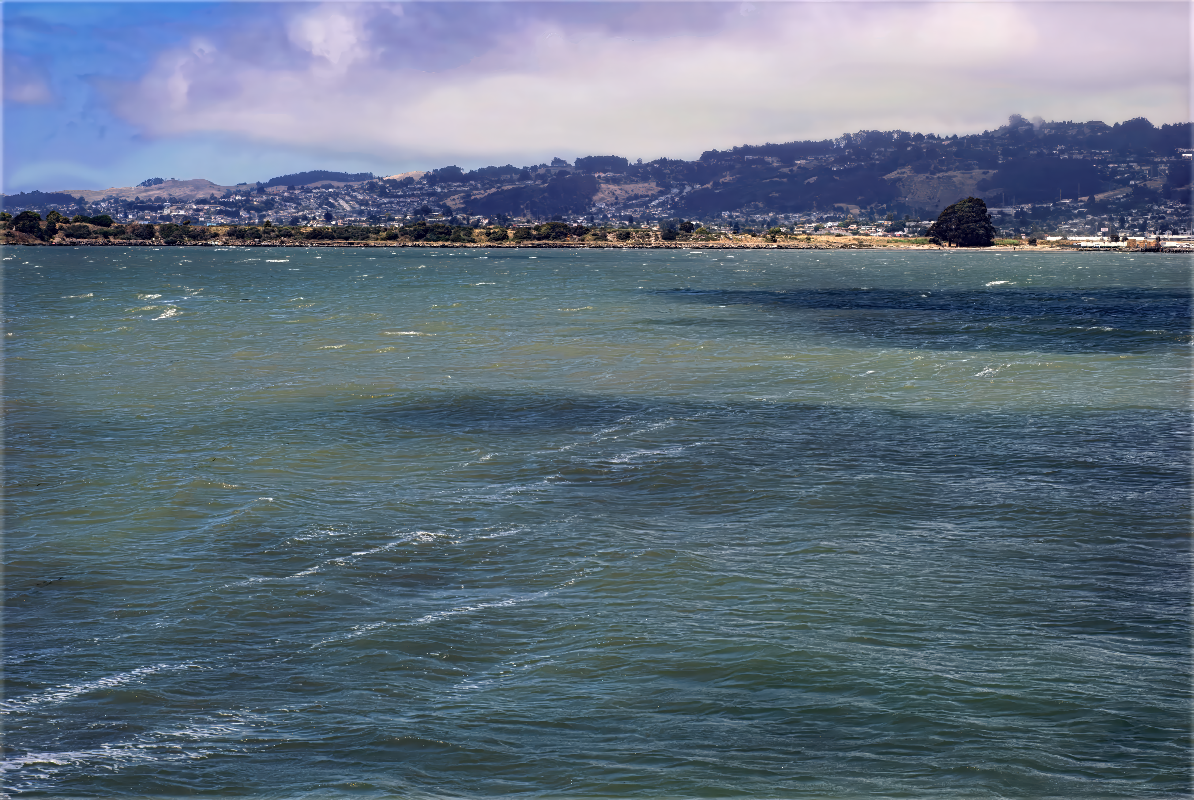 Ocean water with lines of foam in generally flat waves