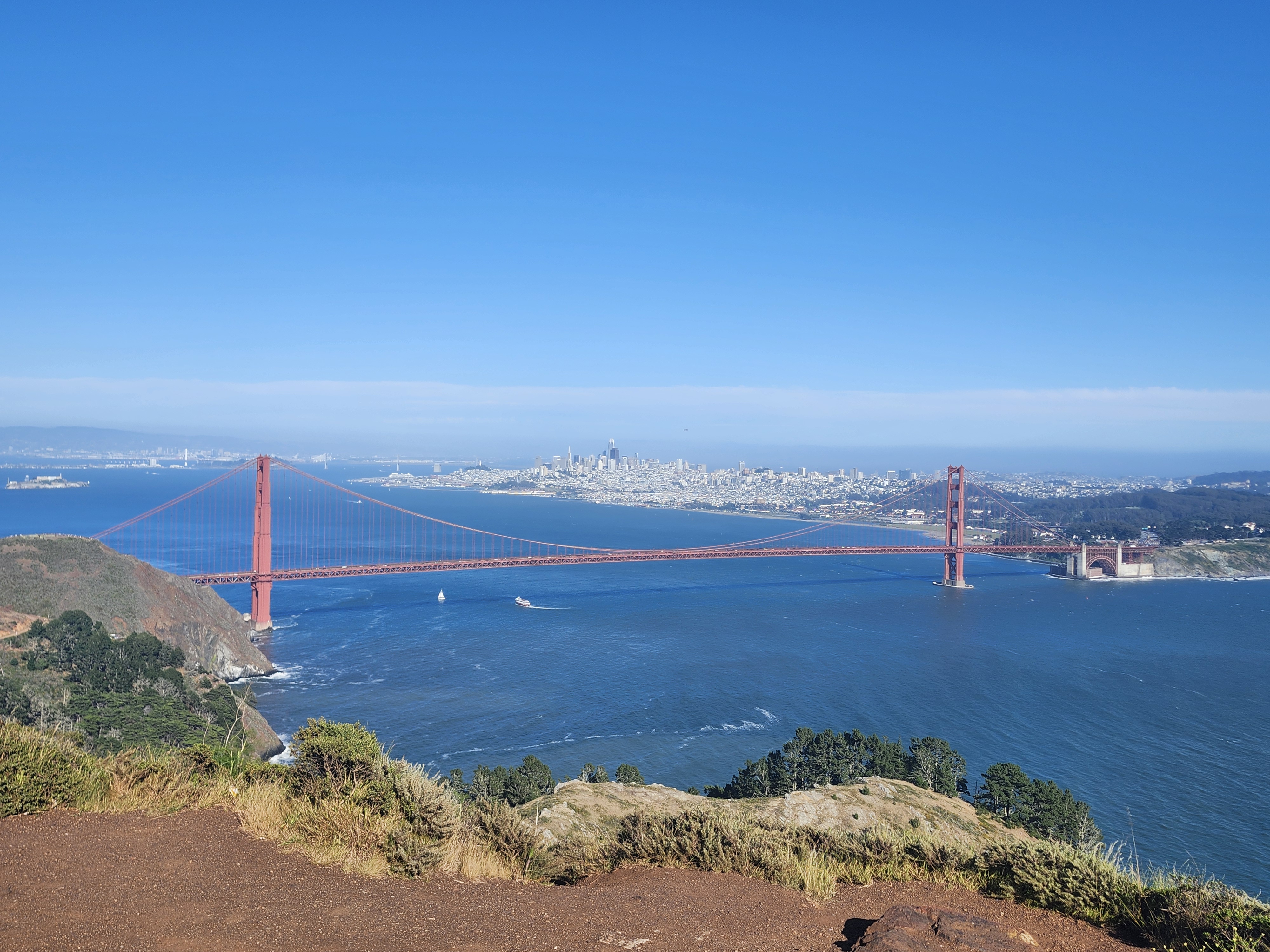 The Golden Gate Bridge with the San Francisco city skyline visible under a clear sky.