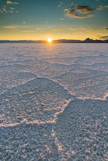 Photo of salt crust at the Bonneville Salt Flats in Utah with mountains in the background.