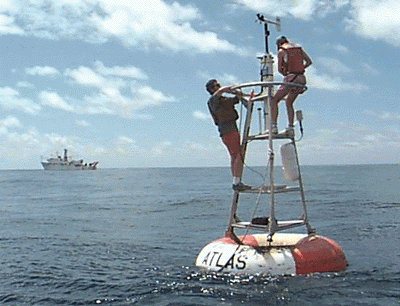Two researchers collecting data from a buoy