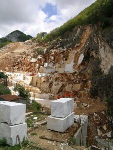 The image shows a hillside with blocks of marble removed.