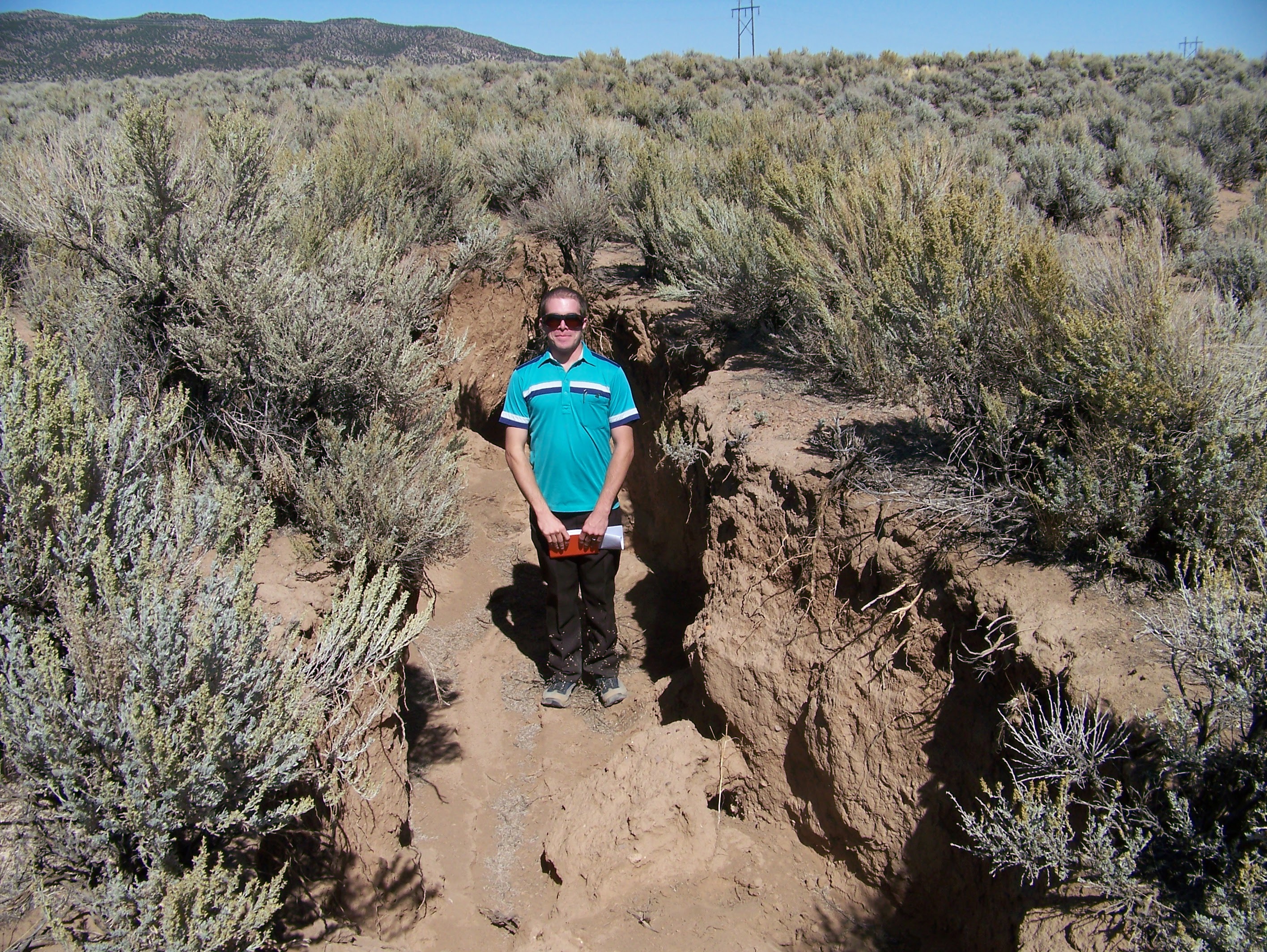 The author stands in a large ditch-like