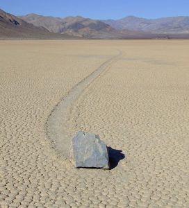 A large rock has slid over the playa surface leaving a track in the mud.