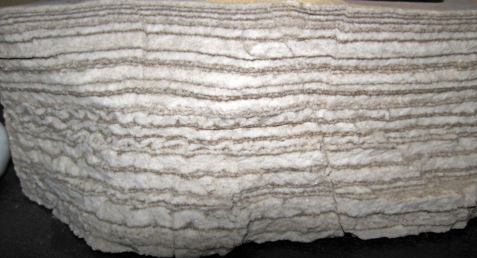 The rock has many light-colored layers.