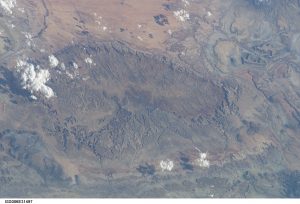 View of a dome in Utah from space. The photo shows upwarped beds of rock, where the center of the dome has been eroded away.