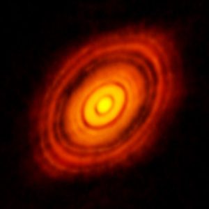 The orange disk has zones that are darker, indicating the planets are growing by using that material in the disk.