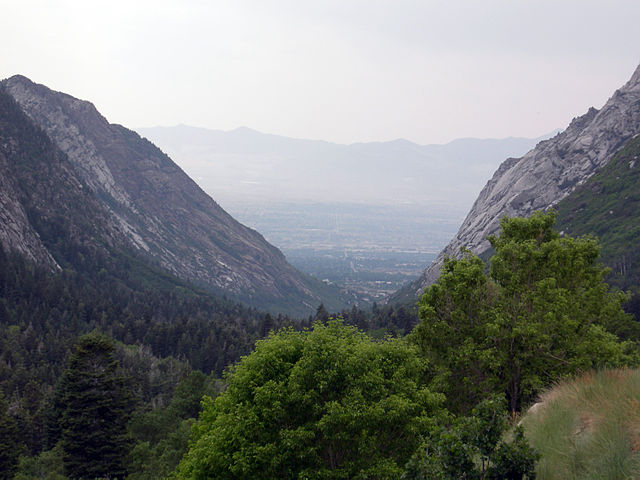 A valley with a u shape that shows steep cliffs on the sides and a wide-flat bottom