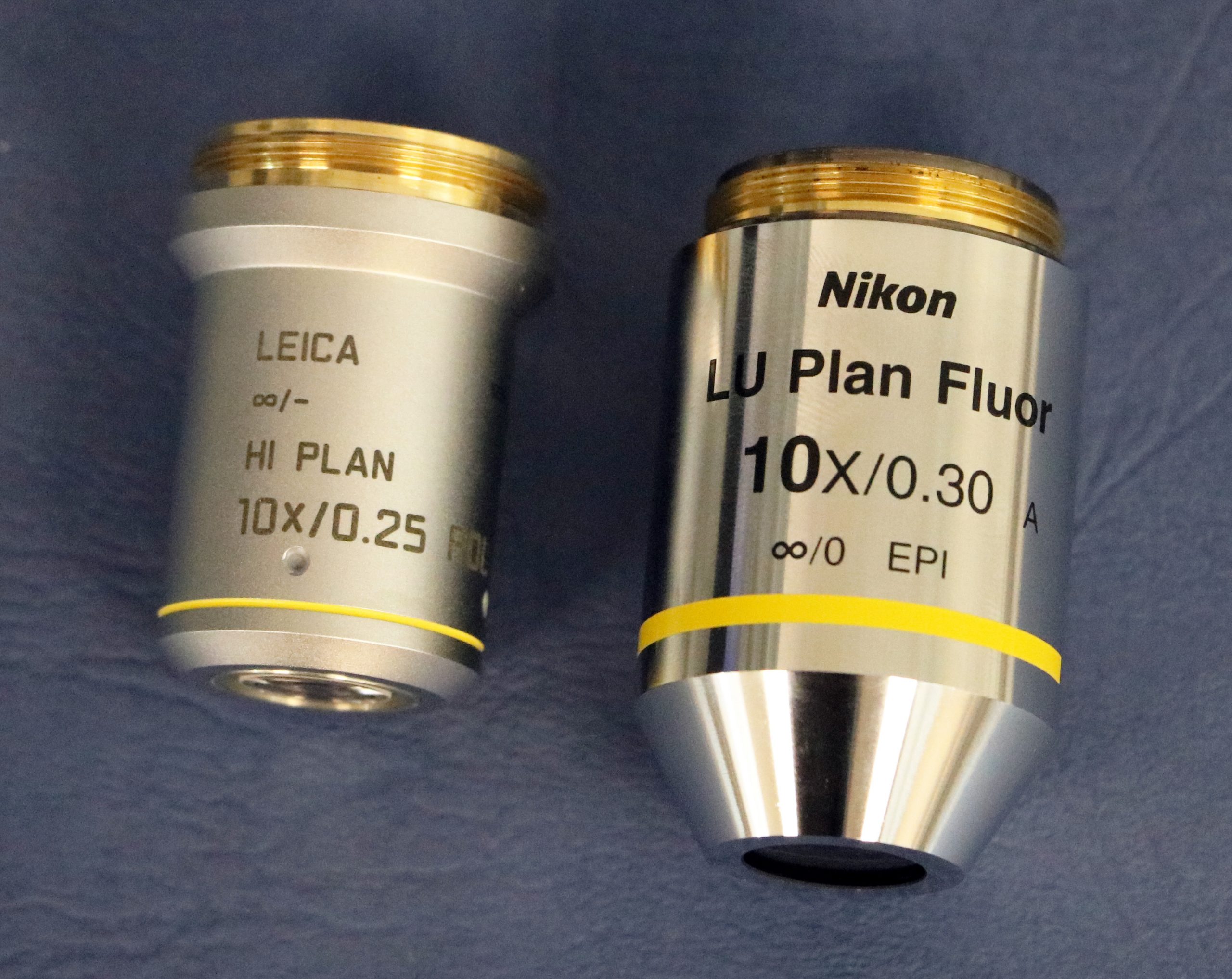 Figure 2.4.12 Objective lenses from two brands of polarizing light microscope. The magnification (10x) and numeric aperture (0.25 and 0.30) are written on each objective.
