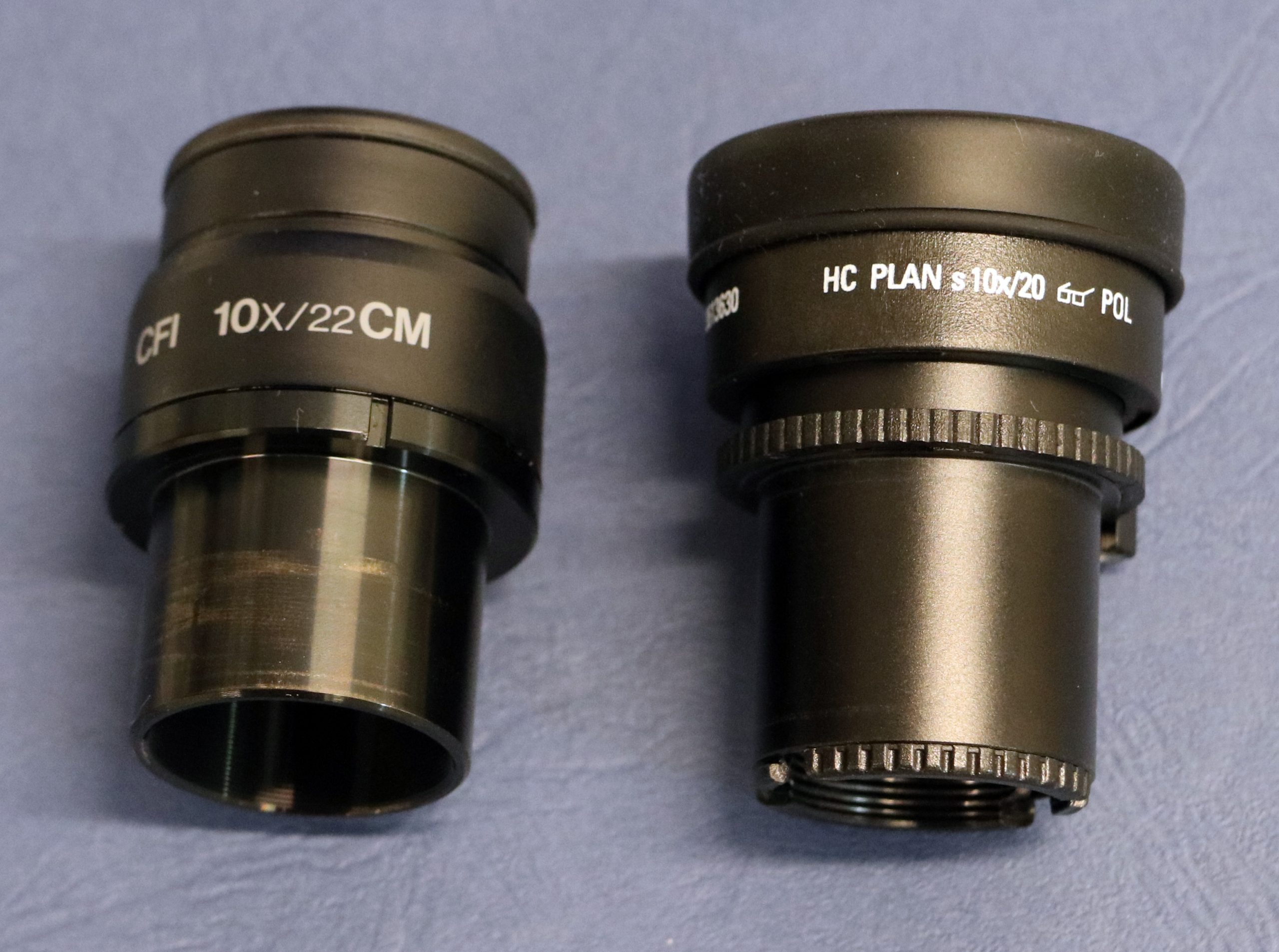 Figure 2.4.15. Eyepieces or oculars removed from two different brands of polarizing light microscope. The magnification (10x) is marked on each ocular.