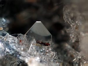Figure 2.6.6 A. A colorless forsterite crystal (olivine group) from Wannenköpfe, Ochtendung, Eifel region, Germany.