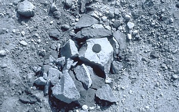 Tephra block (also called a ballistic) on the crater floor of Mount St. Helens about 100 m from the lava dome. This lava fragment was blasted from the dome by a short-lived explosion caused by either (1) a vigorous release of gas from magma within or beneath the dome; or (2) by superheated groundwater "flashing" to steam. The rock broke apart when it landed on the crater floor.